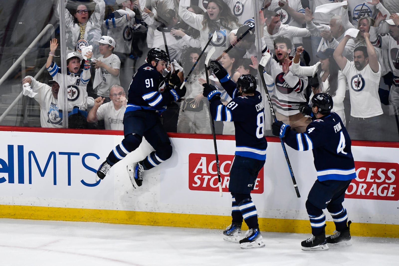 Winnipeg Jets' Cole Perfetti (91) celebrates after his goal to tie the St. Louis Blues with Kyle Connor (81) and Neal Pionk (4) during the third period of Game 7 in an NHL hockey first-round playoff series in Winnipeg, Manitoba, Sunday, May 4, 2025. (Fred Greenslade/The Canadian Press via AP)