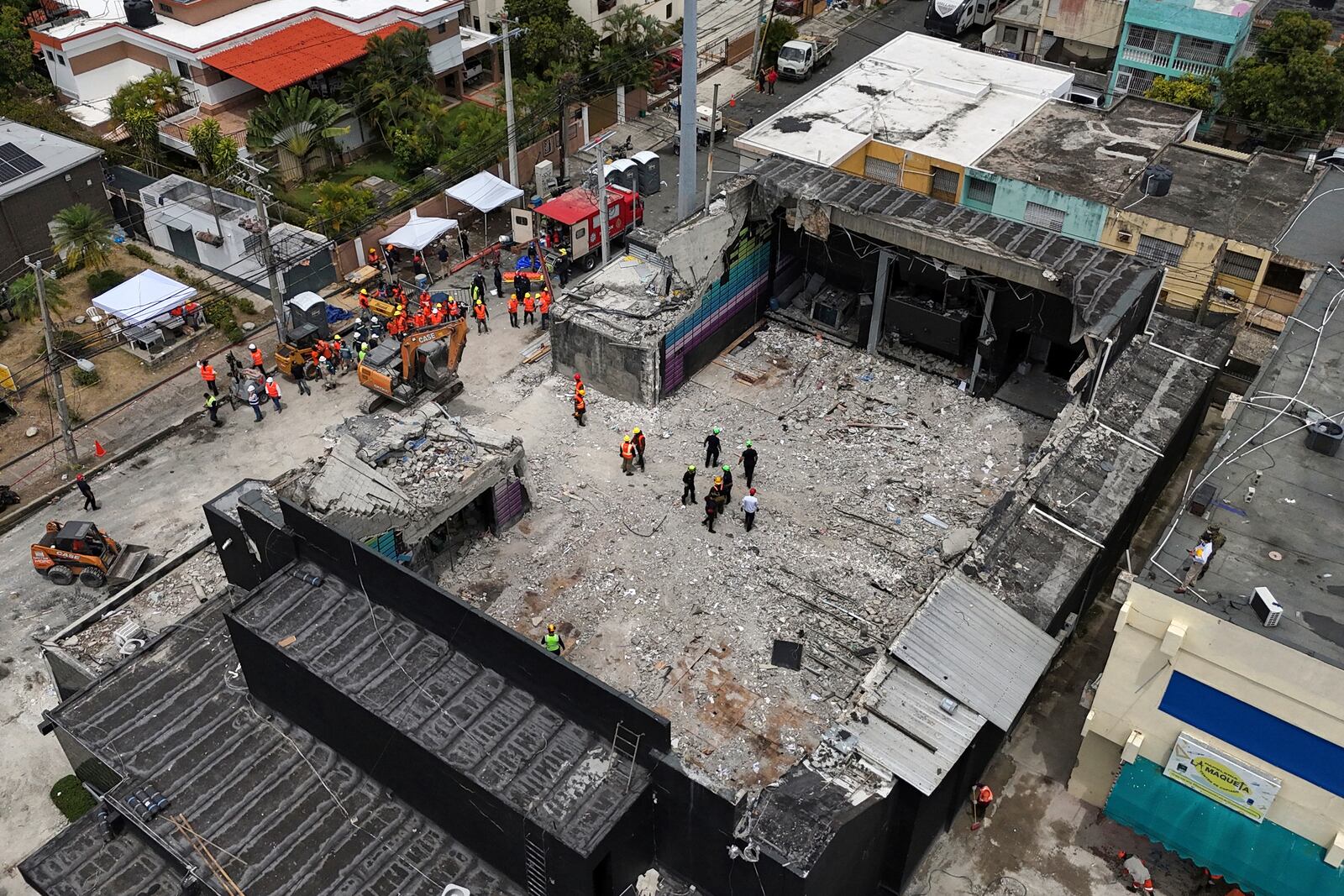 Rescue workers stand at the Jet Set nightclub days after its roof collapsed, killing more than 200 people in Santo Domingo, Dominican Republic, Thursday, April 10, 2025. (AP Photo/Matias Delacroix)