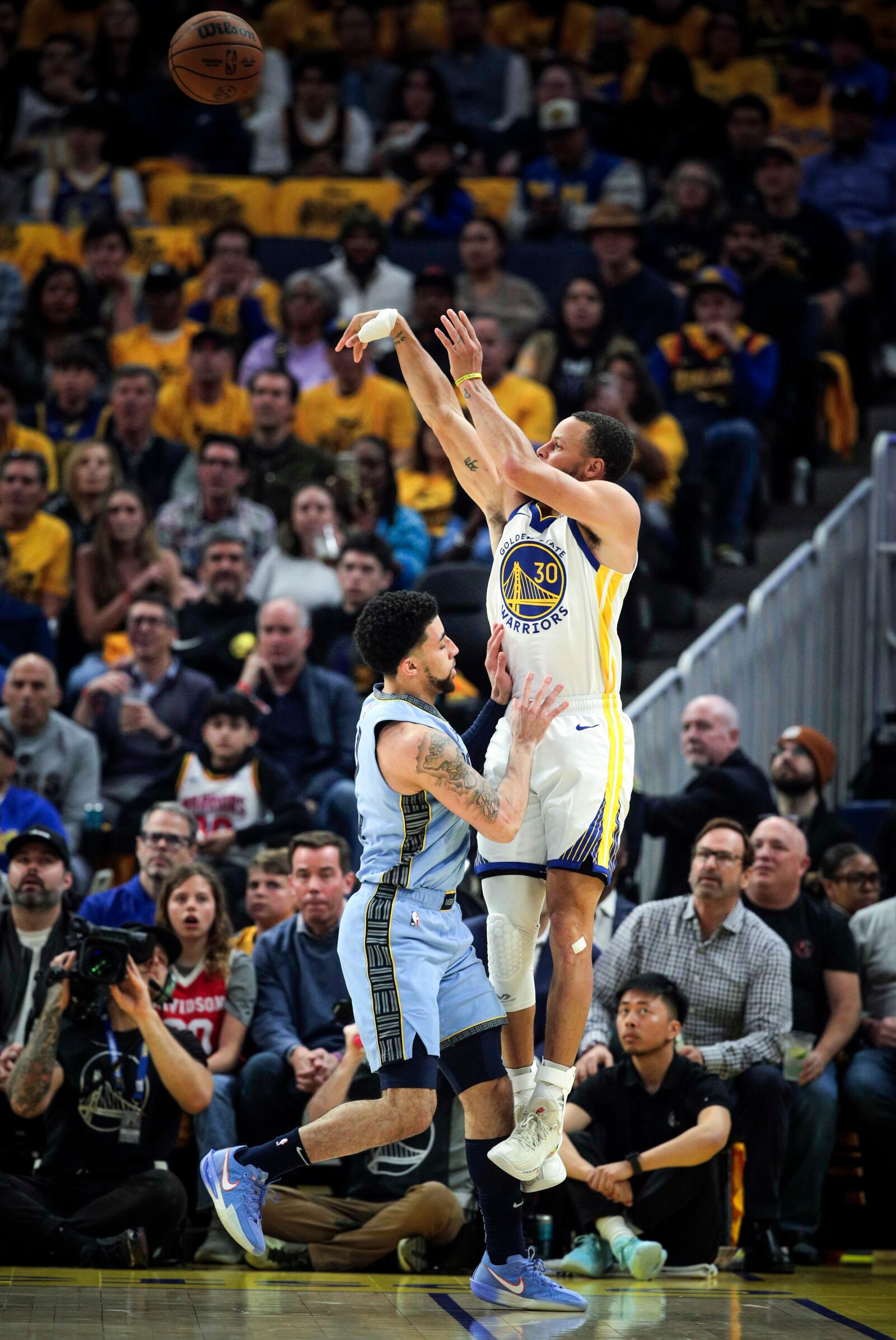 Golden State Warriors' Stephen Curry (30) shoots a 3-point shot as Memphis Grizzlies' Scotty Pippen Jr. (1) fouls him in the first half of an NBA play-in tournament basketball game in San Francisco, Tuesday, April 15, 2025. (Carlos Avila Gonzalez/San Francisco Chronicle via AP)