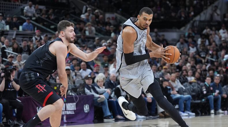 San Antonio Spurs forward Victor Wembanyama (1) drives around Houston Rockets center Alperen Sengun (28) during the first half of an NBA basketball game in San Antonio, Sunday, March 8, 2026. (AP Photo/Eric Gay)
