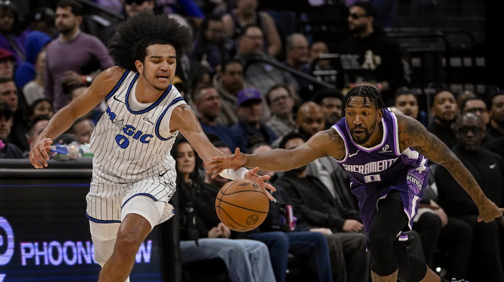 Orlando Magic guard Anthony Black, left, and Sacramento Kings guard Malik Monk, right, chase the ball during the first half of an NBA basketball game in Sacramento, Calif., Thursday, Feb. 19, 2026. (AP Photo/Randall Benton)