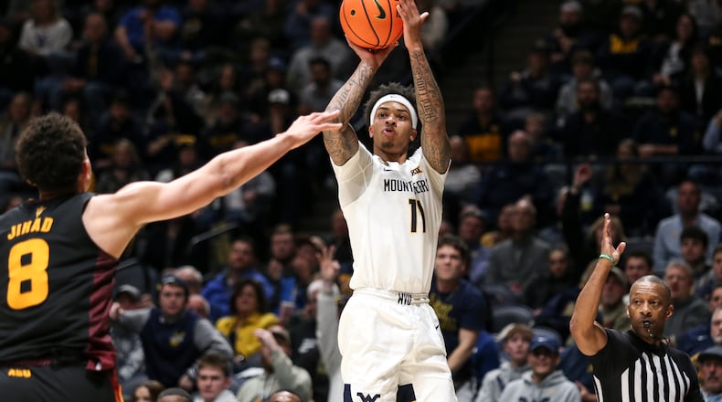 West Virginia guard Jonathan Powell (11) handles the ball while being guarded by Arizona State forward Basheer Jihad (8) during the first half of an NCAA college basketball game, Tuesday, Jan. 21, 2025, in Morgantown, W.Va. (AP Photo/William Wotring)