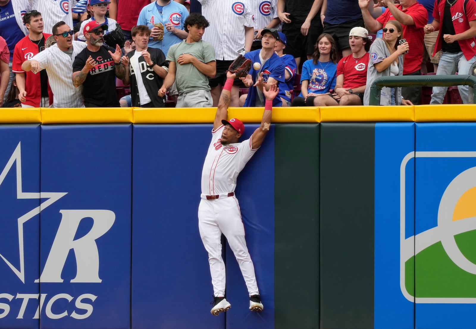 Cincinnati Reds right fielder Will Benson leaps for but misses a solo home run hit by Chicago Cubs' Reese McGuire in the second inning of a baseball game, Sunday, May 25, 2025, in Cincinnati. (AP Photo/Carolyn Kaster)