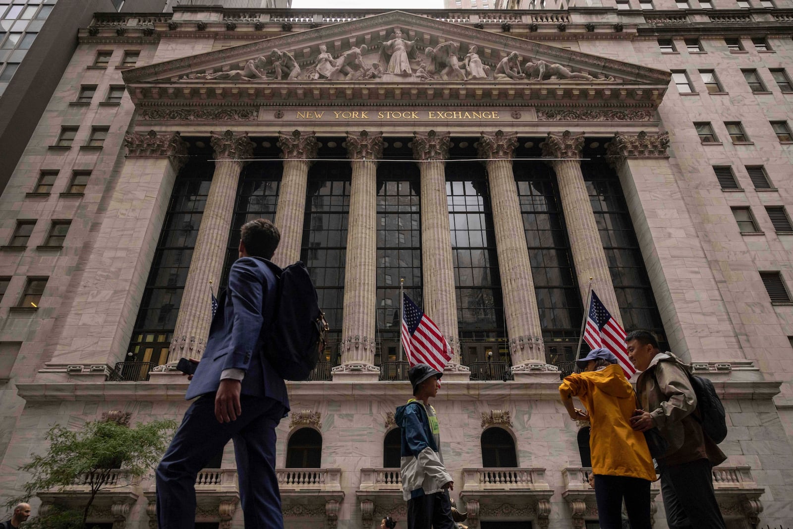 People walk past the New York Stock Exchange, Wednesday, June 18, 2025, in New York. (AP Photo/Yuki Iwamura)