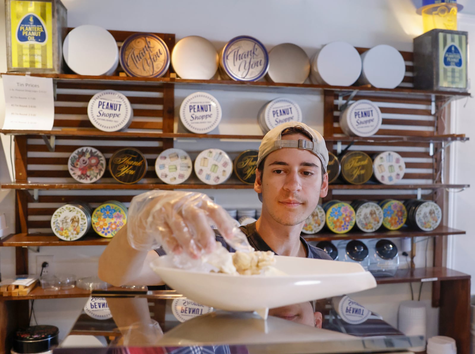 Worker Jadon Dennis puts peanuts on a scale at the Peanut Shoppe on Wednesday, September 3, 2025, in Springfield. JOSEPH COOKE/STAFF 