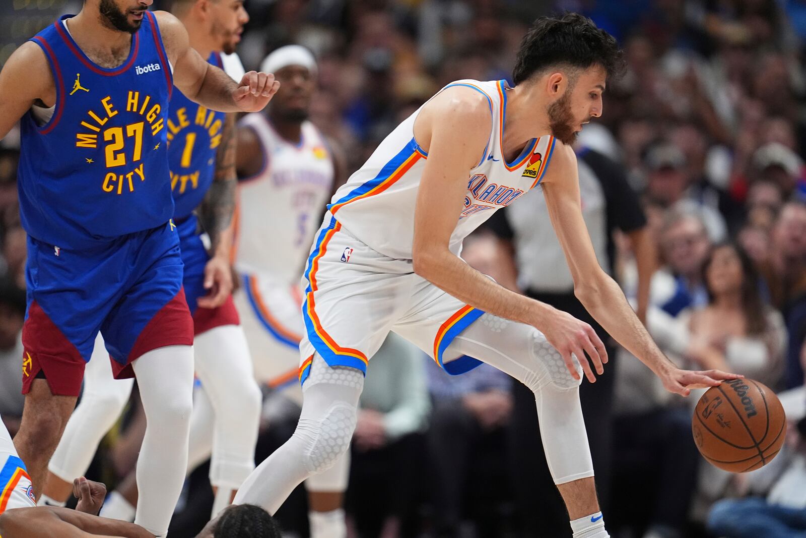 Oklahoma City Thunder forward Chet Holmgren, right, collects the ball as Denver Nuggets guard Jamal Murray (27) defends in the first half of Game 3 in the Western Conference semifinals of the NBA basketball playoffs Friday, May 9, 2025, in Denver. (AP Photo/David Zalubowski)