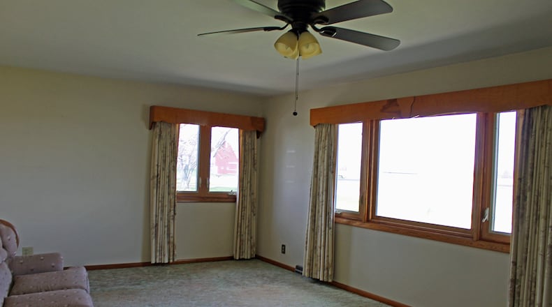 Two large windows in the living room provide views of the front and side yards.
