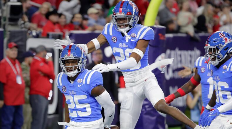 Mississippi safety Trey Washington (25) and cornerback Davison Igbinosun (20) celebrate the end zone interception by Washington against Texas Tech during the first half of the Texas Bowl NCAA college football game Wednesday Dec. 28, 2022, in Houston. (AP Photo/Michael Wyke)