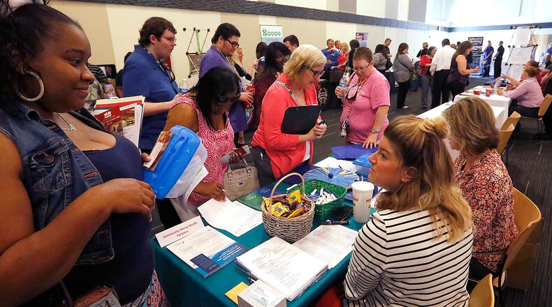 A group of people looking for jobs crowd around the Mercy Health-Springfield table at the Chamber of Greater Springfield and OhioMeansJobs Clark County job fair in 2016. Bill Lackey/Staff