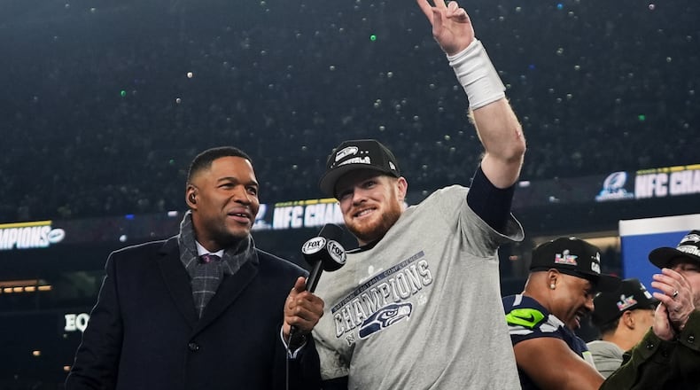 Seattle Seahawks quarterback Sam Darnold, celebrates next to Michael Strahan, left, after a win over the Los Angeles Rams in the NFC Championship NFL football game Sunday, Jan. 25, 2026, in Seattle. (AP Photo/Lindsey Wasson)