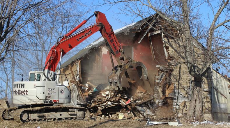 Tony Smith from Smith Wrecking demolishes this home on Broadgauge Road in Clark County on Wednesday morning. Clark County received about $150,000 in matching grant money to demolish vacant and abandoned homes in the county. Jeff Guerini/Staff