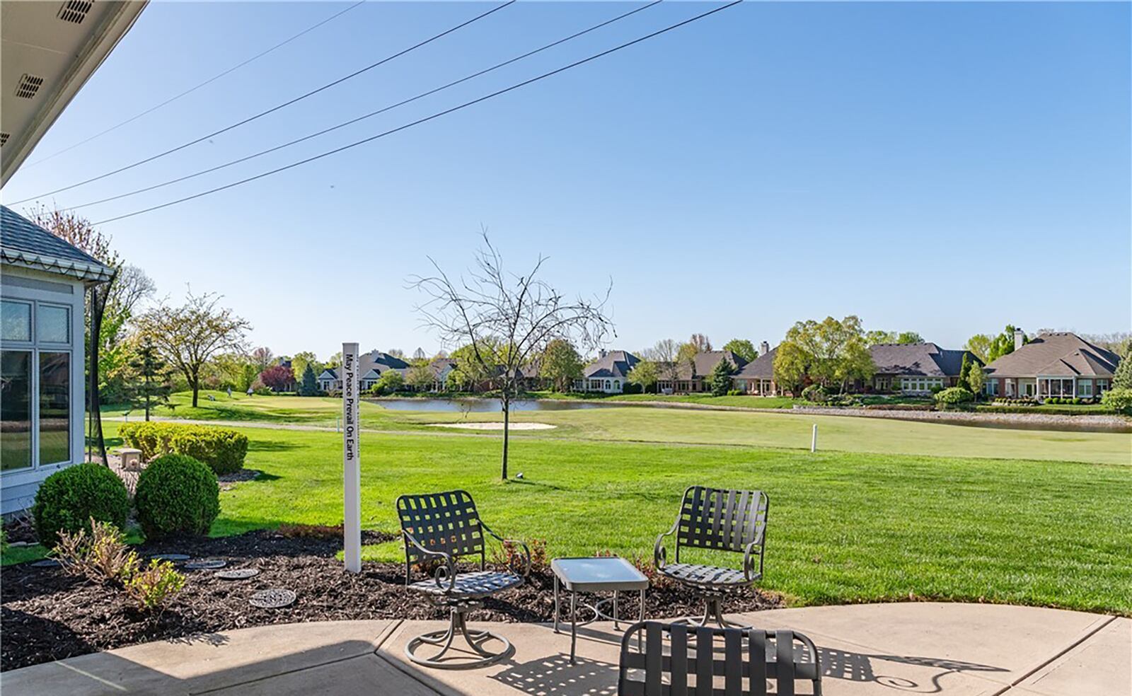 The rear patio has a view of the golf fairway and the lake beyond