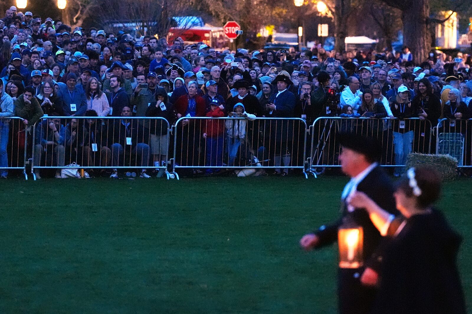 Thousands watch before sunrise during a reenactment celebration of the 250th anniversary of the Battle of Lexington and start of the American Revolution, Saturday, April 19, 2025, in Lexington, Mass. (AP Photo/Charles Krupa)