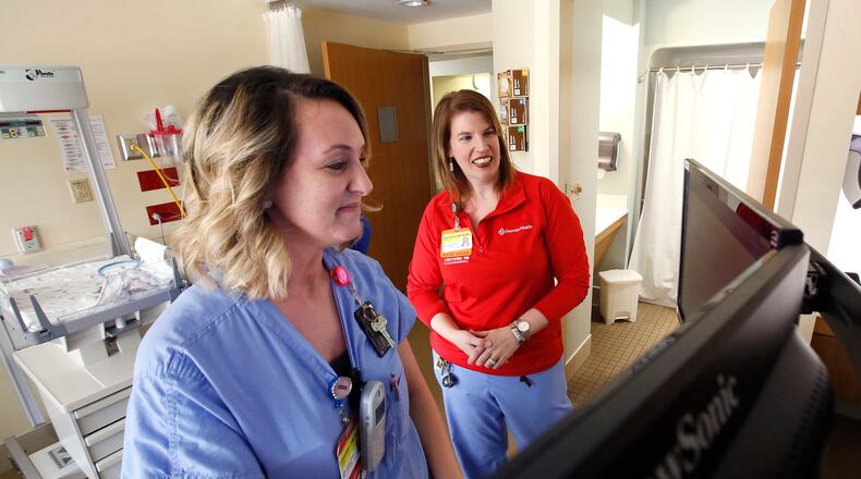 Nurse Emily Hayes, right, reviews patient records with fellow nurse Adrienne Linville at Miami Valley Hospital’s Berry Women’s Center. Demand for registered nurses is high, reflected in online advertising for job openings across Ohio. FILE