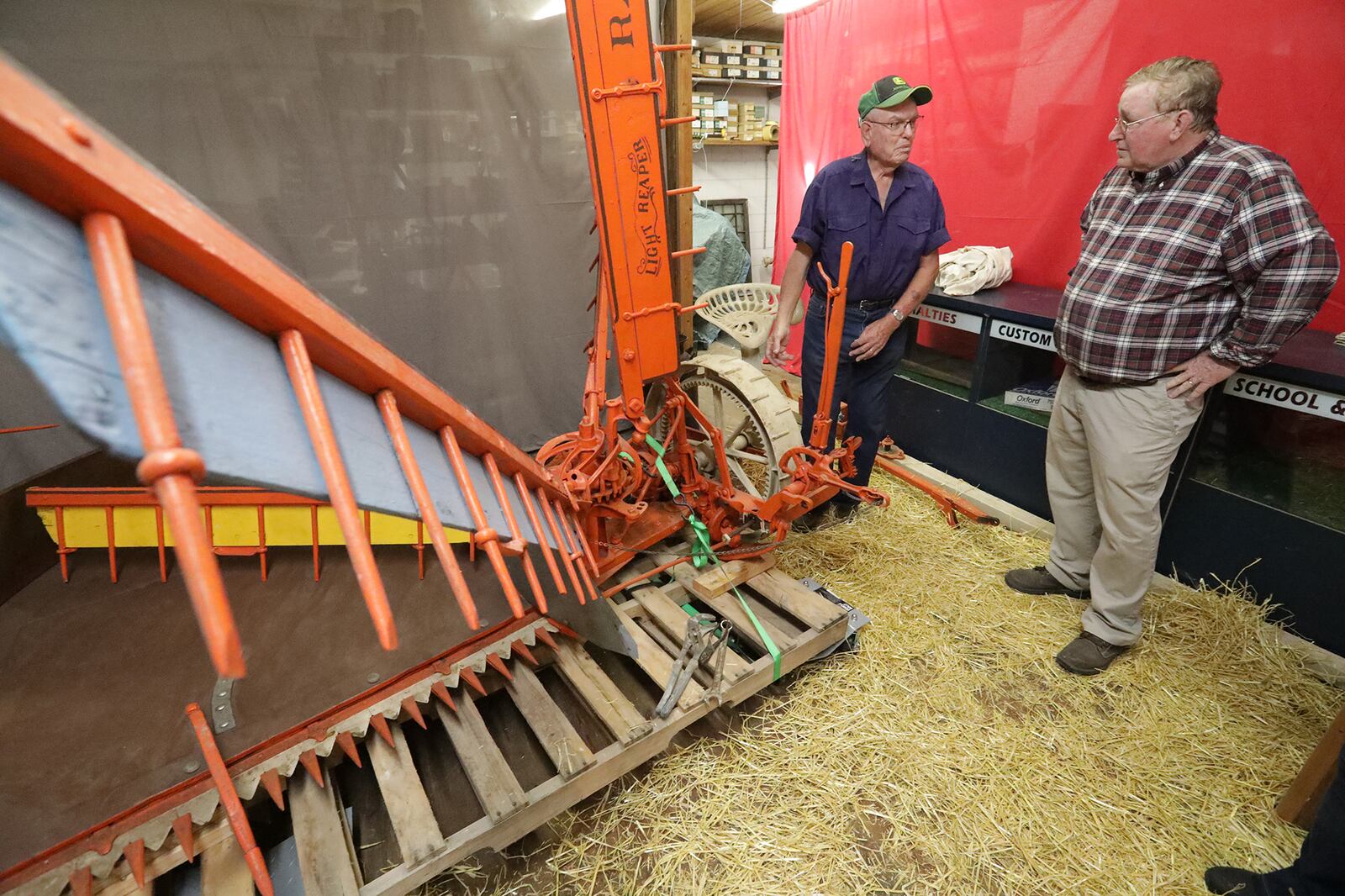 Bob Wood, left, talks with Dan Hearlihy about the antique Champion Reaper Wood and his wife Sharon had just delivered to Hearlihy at his museum Tuesday. BILL LACKEY/STAFF