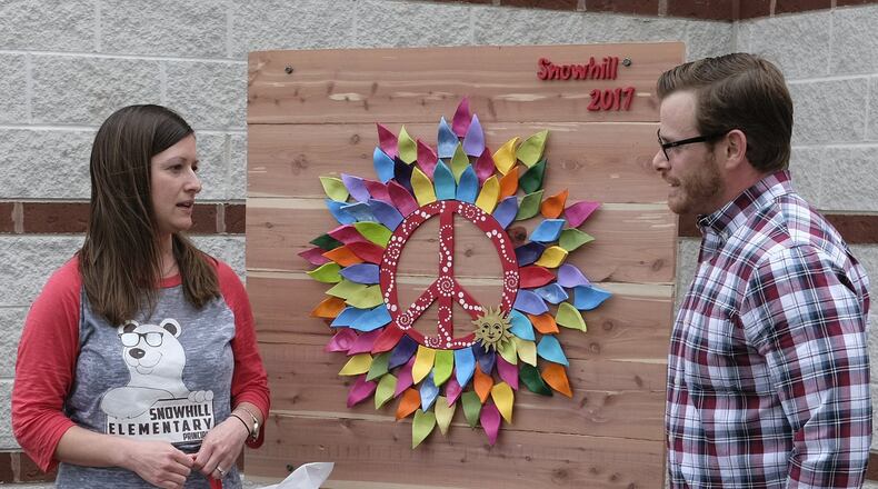 Jennifer Paxson, principal of Snowhill Elementary, talks to artist Jeremy Block, who made the piece of artwork for the front of the school Thursday. The art piece was unveiled during a reception after school. Bill Lackey/Staff