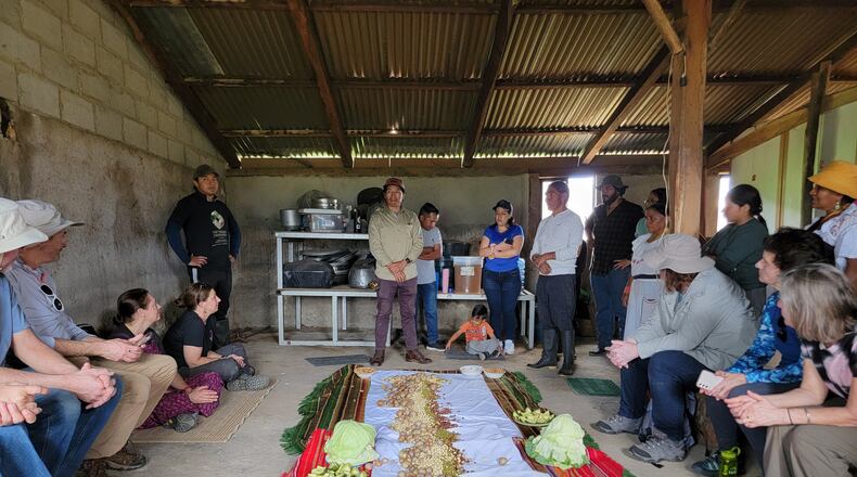 A traditional pambamesa with the local Andean indigenous community. Food is provided by all and spread on the sheet; cabbage leaves are used to hold the food.