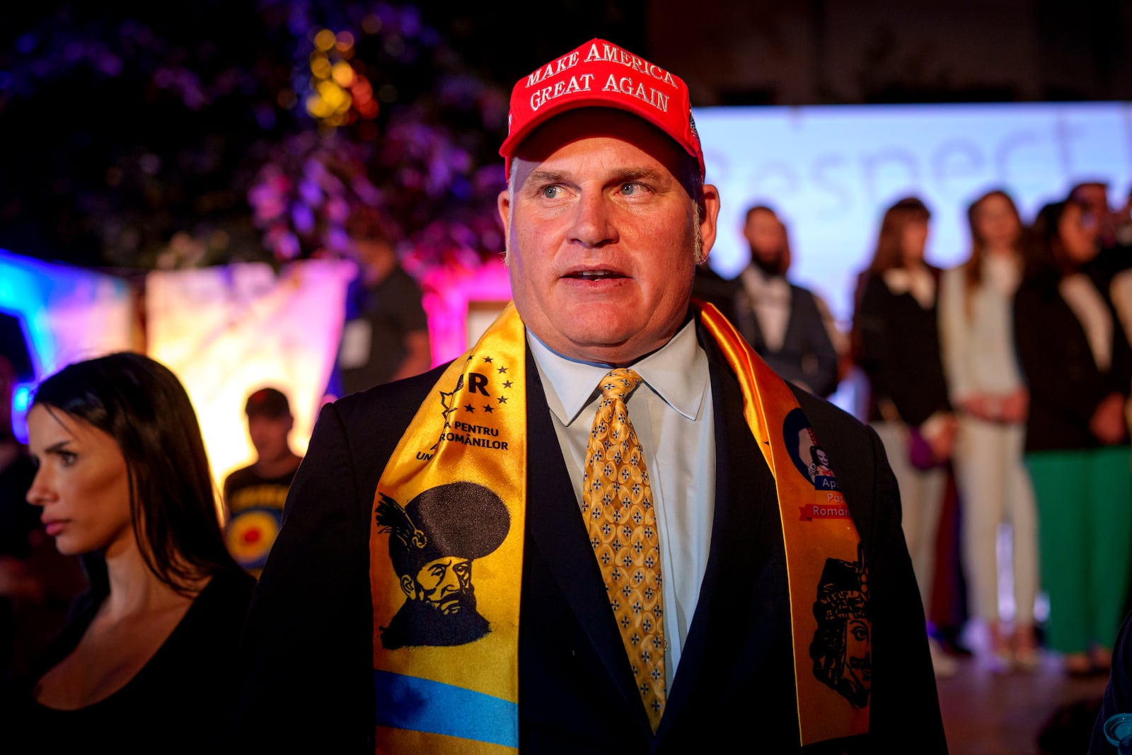U.S. activist Brian Brown stands as supporters of presidential candidate George Simion celebrate the exit poll results at the headquarters of the Alliance for the Unity of Romanians (AUR) after polls closed for the first round of the country's presidential election redo in Bucharest, Romania, Sunday, May 4, 2025. (AP Photo/Andreea Alexandru)
