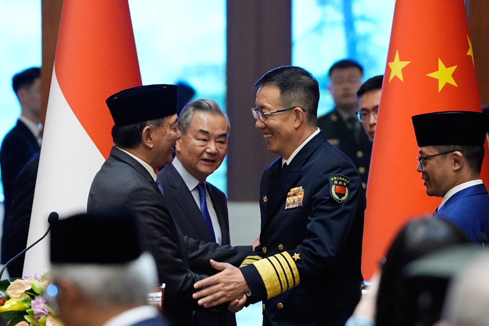 Indonesian Defense Minister Sjafrie Sjamsoeddin, center left, and Chinese Defense Minister Dong Jun, center right, shake hands as Chinese Foreign Minister Wang Yi, center, and Indonesian Foreign Minister Sugiono, right, look on after a press briefing about the first meeting of China-Indonesia joint foreign and defense ministerial dialogue at the Diaoyutai State Guest House in Beijing Monday, April 21, 2025. (Iori Sagisawa/Pool Photo via AP)