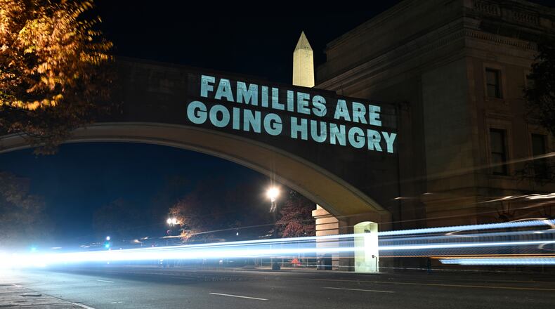 A message from the National Women's Law Center concerning the announcement by the Trump administration of restoring only half funding the SNAP benefits is projected on the U.S. Department of Agriculture building, Monday, Nov. 3, 2025, in Washington. (AP Photo/John McDonnell)