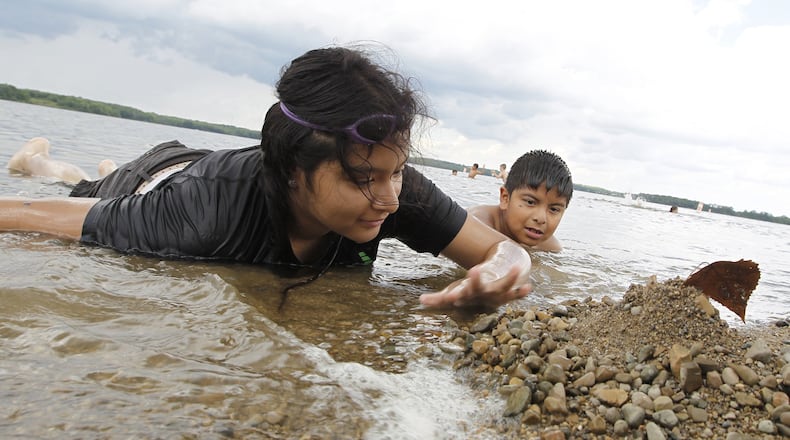 Perla Manzano, 14, and her brother, Juan, 9, pile up rocks along the shore line as they play in the water at the Buck Creek State Park beach Monday, June 19, 2017. BILL LACKEY/STAFF