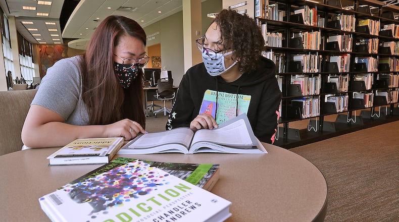 Clark State College students Gracie Perkins, left, and Jasmin Alford study about addiction Thursday in the Clark State Library. BILL LACKEY/STAFF