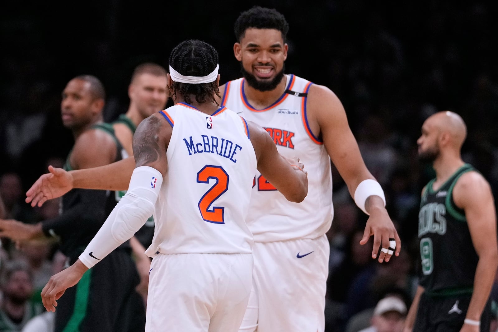 New York Knicks center Karl-Anthony Towns, rear, is congratulated by guard Miles McBride (2) during the first half of Game 5 of an NBA basketball second-round playoff series against the Boston Celtics, Wednesday, May 14, 2025, in Boston. (AP Photo/Charles Krupa)
