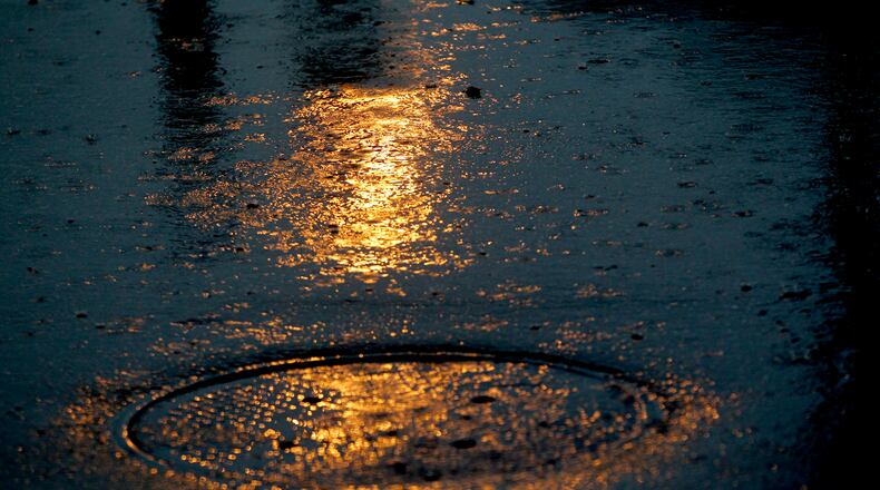 Rain falls across a parking lot in Dayton. LISA POWELL / STAFF
