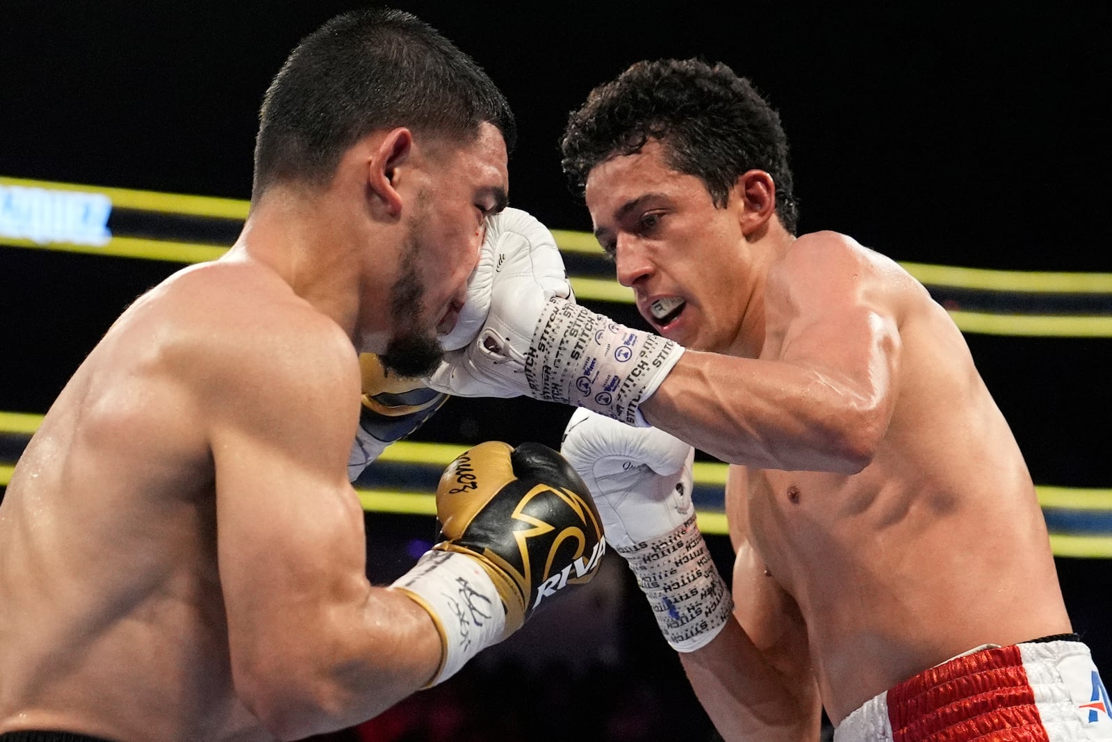 Rafael Espinoza hits Edward Vazquez in a featherweight title boxing match Sunday, May 4, 2025, in Las Vegas. (AP Photo/John Locher)