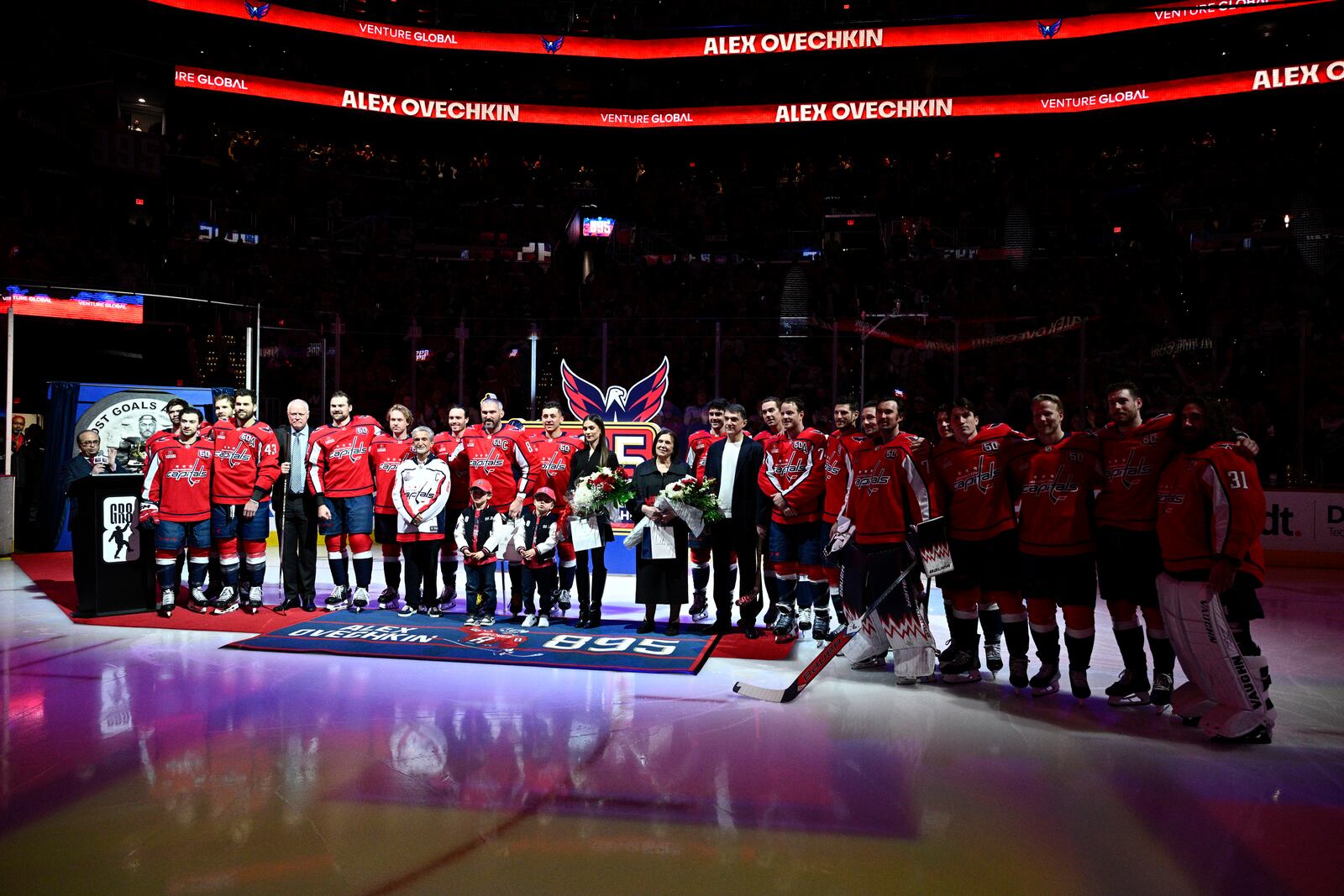 The Washington Capitals and others pose for a photo during a ceremony to honor Alex Ovechkin (8) for scoring 895 career NHL goals before an NHL hockey game against the Carolina Hurricanes, Thursday, April 10, 2025, in Washington. (AP Photo/Nick Wass)