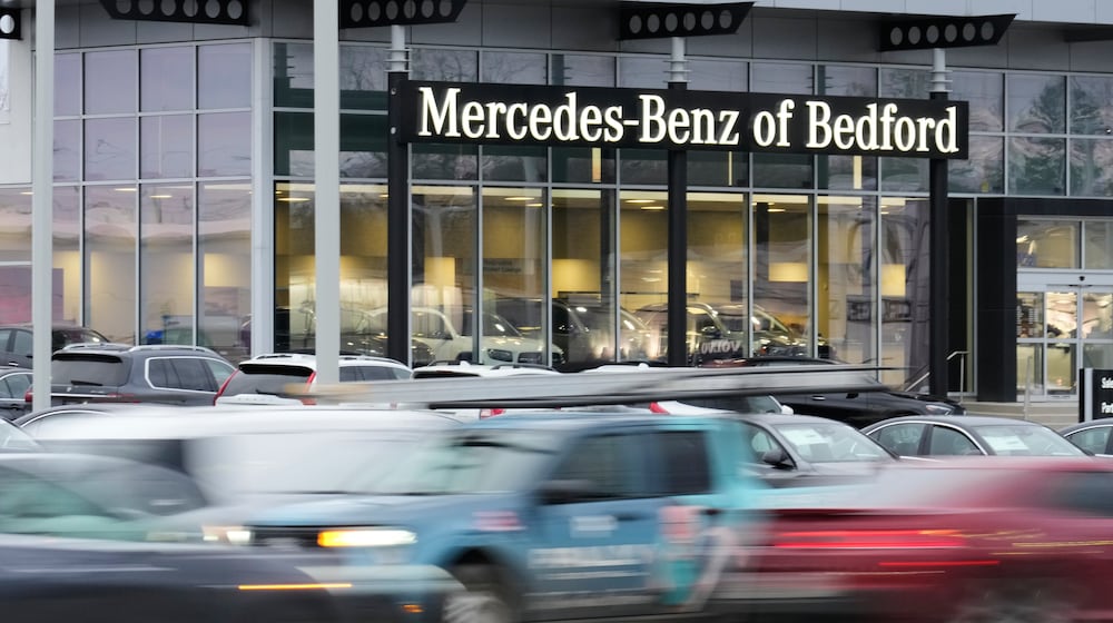 Cars drive by a Mercedes-Benz dealership on the Bedford Automile in Bedford, Ohio, Friday, Feb. 20, 2026. (AP Photo/Sue Ogrocki)