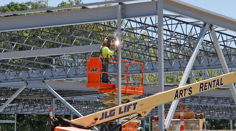 A worker welds a section of the framework for the new Global Impact STEM Acedemy's Upper Academy expansion on the Clark State College Leffel Lane Campus Monday, July 1, 2024. BILL LACKEY/STAFF