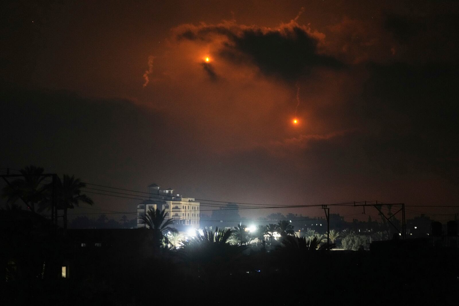 Illumination flares launched by the Israeli army are seen over Deir al-Balah in central Gaza Strip Monday, July 21, 2025. (AP Photo/Abdel Kareem Hana)