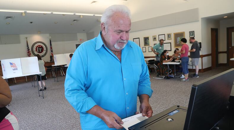 David Secrist puts his ballot in the voting machine at the election poll in the Springfield Township Goverment Center Tuesday, August 2, 2022. BILL LACKEY/STAFF