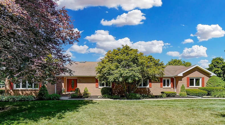 The 4-bedroom, brick ranch offers about 4,820 sq. ft. of living space and has a walk-out, partially finished basement. The front of the home features a concrete extended driveway that leads to the attached, 4-car garage. CONTRIBUTED PHOTO