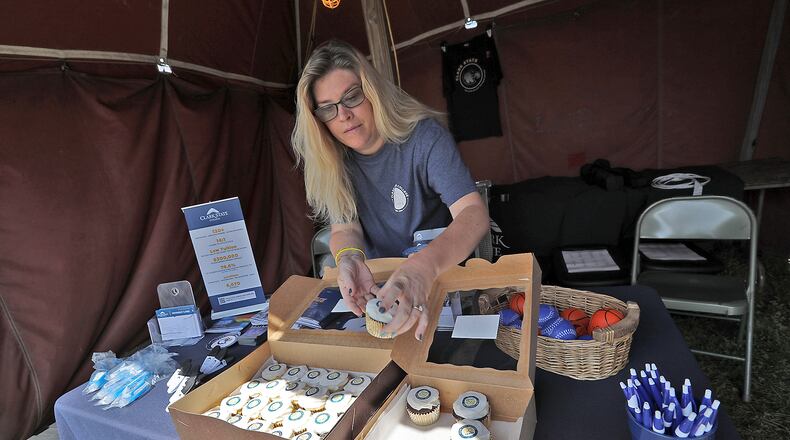 Leslie Ray, from Clark State College, passes out cupcakes for Clark State's 60th Anniversary Thursday, July 28, 2022 in their booth at the Clark County Fair. BILL LACKEY/STAFF