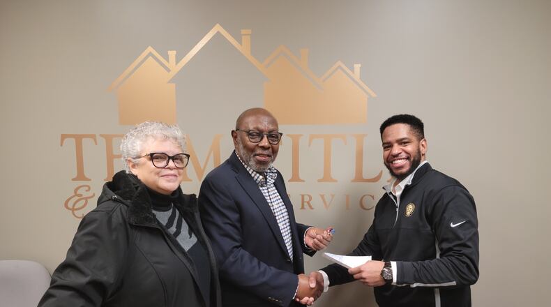 Urban Light Ministries co-founders, from left, Judy and Eli Williams turn over the deed to the ministry's former offices to Karlos L. Marshall, co-founder of The Conscious Connect CDC after closing on the deal on Jan. 18. ULM has a new office at Commerce Pointe and The Conscious Connect is expanding into Clark County. CONTRIBUTED PHOTO