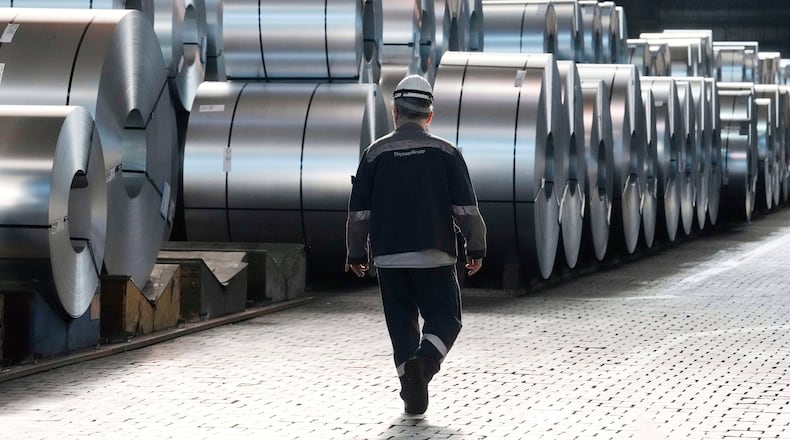 FILE - A steel worker walks beside steel coils during a visit of EU Commissioner for Prosperity and Industrial Strategy Stephane Sejourne at the Thyssenkrupp steelworks in Duisburg, Germany, after the EU Steel Action plan was presented, Thursday, March 20, 2025. (AP Photo/Martin Meissner, File)