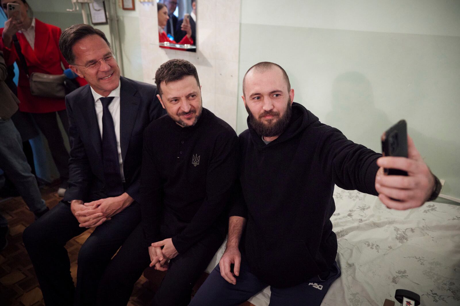 In this photo provided by the Ukrainian Presidential Press Office, NATO Secretary General Mark Rutte, left, and Ukraine's President Volodymyr Zelenskyy, centre, pose for photo with a wounded Ukrainian soldier during their visit to a hospital in Odesa, Ukraine, Tuesday, April 15, 2025.(Ukrainian Presidential Press Office via AP)