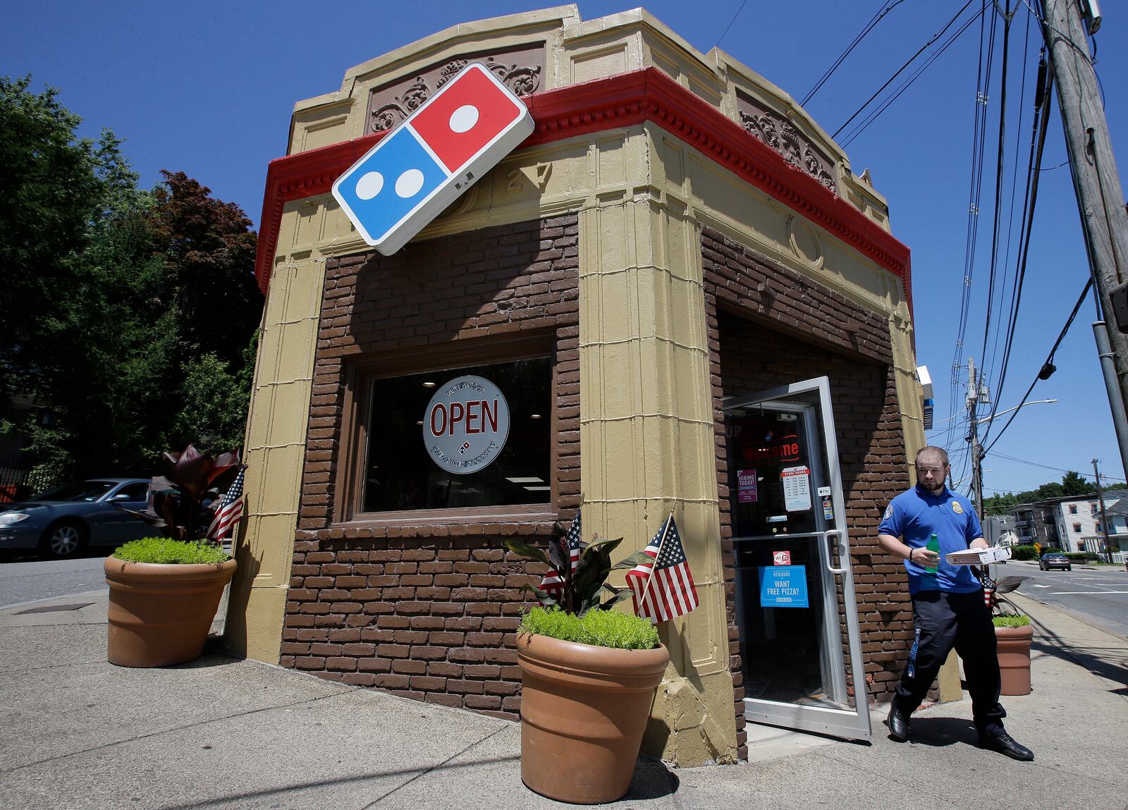 FILE - A customer leaves a Domino's pizza shop in Norwood, Mass., July 15, 2019. (AP Photo/Steven Senne, File)