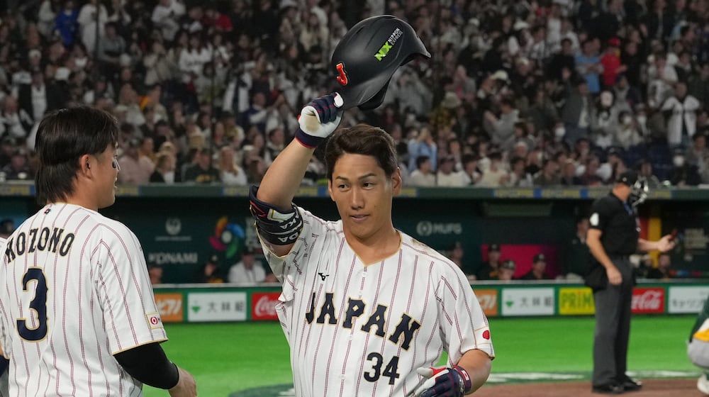 Japan's Masataka Yoshida, center, reacts after hitting two-run home run during the seventh inning of a World Baseball Classic game between Japan and Australia on Sunday, March 8, 2026 in Tokyo. (AP Photo/Hiro Komae)