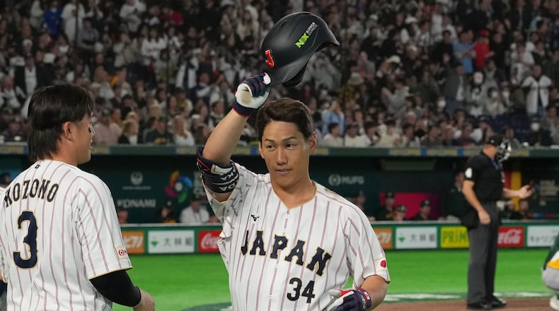 Japan's Masataka Yoshida, center, reacts after hitting two-run home run during the seventh inning of a World Baseball Classic game between Japan and Australia on Sunday, March 8, 2026 in Tokyo. (AP Photo/Hiro Komae)