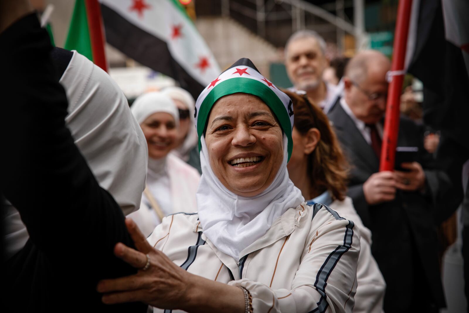 People gather before Syria's Foreign Minister Asaad Al-Shibani arrives to attend a ceremony where the Syrian flag was added to the 100 flags flying in line at United Nations Headquarters on Friday, April 25, 2025. (AP Photo/Kena Betancur)