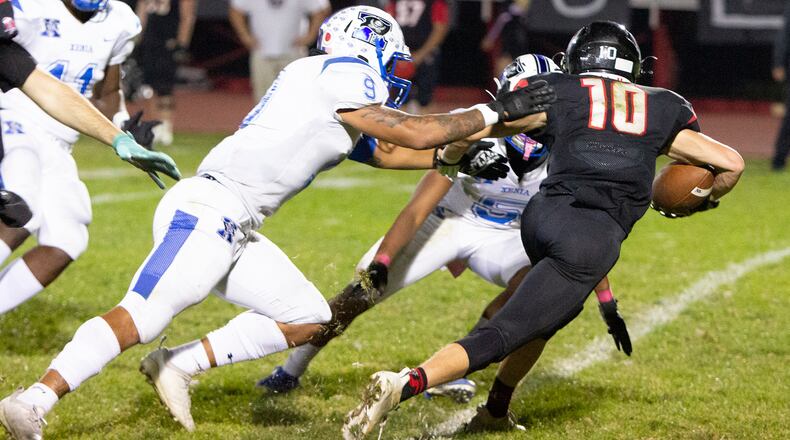 Xenia linebacker Isaiah Hoyt (9) and Tawfiq Jabbar Jr. hem in Tecumseh's Braden Berner during Xenia's 18-0 Division II playoff victory Friday at Tecumseh. Jeff Gilbert/CONTRIBUTED
