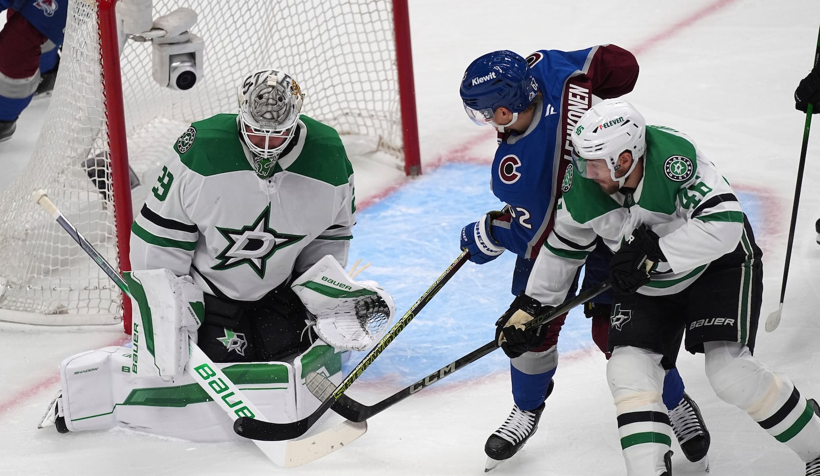 Colorado Avalanche left wing Artturi Lehkonen, center, shoots against Dallas Stars goaltender Jake Oettinger, left, after driving past defenseman Ilya Lyubushkin, right, in the first period of Game 6 of an NHL hockey first-round playoff series Thursday, May 1, 2025, in Denver. (AP Photo/David Zalubowski)