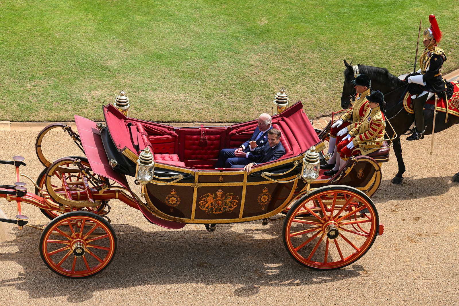 Britain's King Charles III, left, and French President Emmanuel Macron arrive at Windsor Castle in Windsor, England, Tuesday July 8, 2025, on the first day of a three-day state visit to Britain. (Jaimi Joy/Pool via AP)