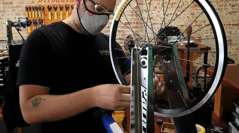 Jon Francis, the owner of Cyclotherapy, working on a clients bicycle wheel Thursday. He was a finalist in the Springfield Hustles competition last year. BILL LACKEY/STAFF
