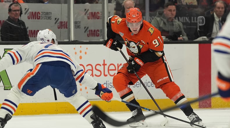Anaheim Ducks center Leo Carlsson (91) looks to pass as Edmonton Oilers defenseman Darnell Nurse defends during the first period of an NHL hockey game Wednesday, Feb. 25, 2026, in Anaheim, Calif. (AP Photo/Gregory Bull)