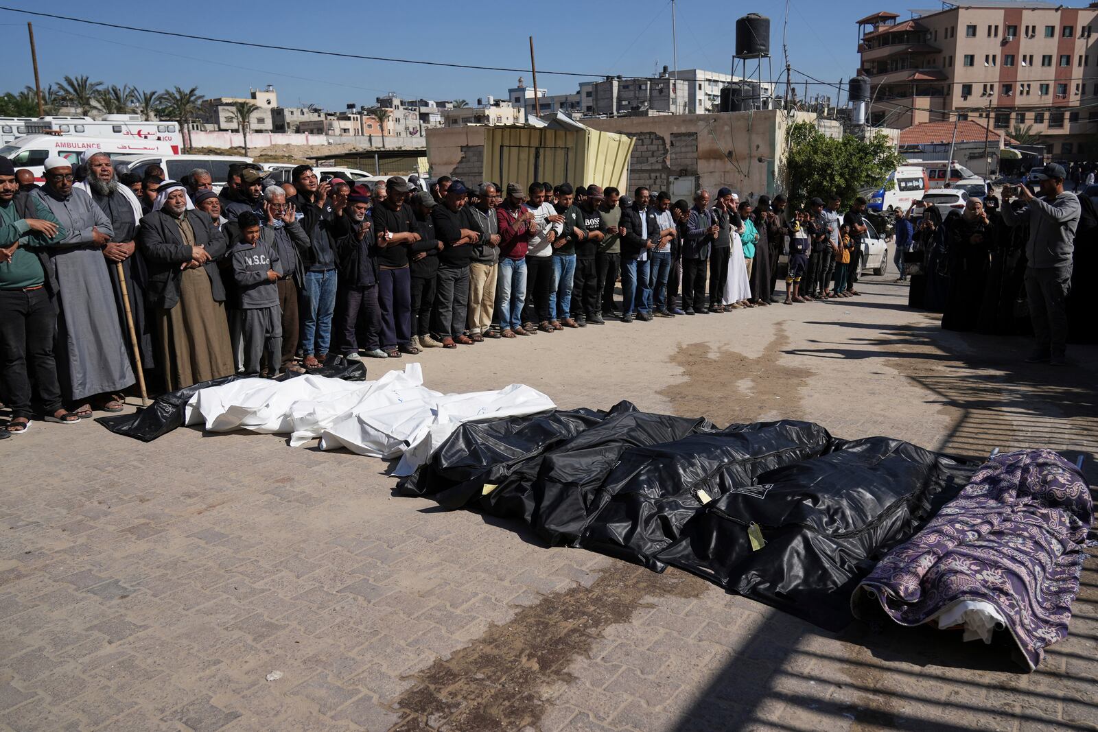 Mourners pray over the bodies of 10 members of the Abu Al-Rous family, killed when an Israeli airstrike struck their displacement tent overnight, during their funeral in Khan Younis, southern Gaza Strip, Thursday, April 17, 2025. (AP Photo/Abdel Kareem Hana)