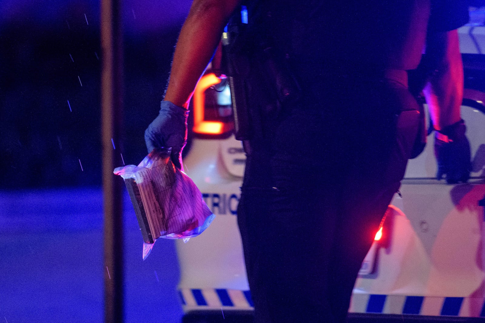 A Washington D.C. Metro police office carries an evidence bag to his car as law enforcement work the scene after two staff members of the Israeli Embassy in Washington were shot and killed outside the Capital Jewish Museum, Thursday, May 22, 2025, in Washington. (AP Photo/Rod Lamkey, Jr.)